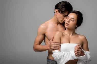 Gri renkli gözleriyle sarılan güzel, şehvetli genç çift.