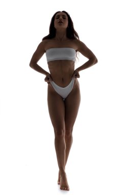 Beyaz iç çamaşırlı, beyaz tenli, seksi bir kadın silueti