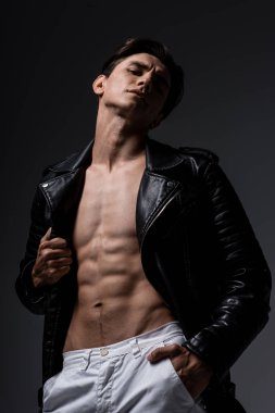 shirtless sexy man in black leather jacket, isolated on grey clipart