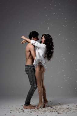 Neşeli çift sarılıyor ve gri tüylerle eğleniyor.