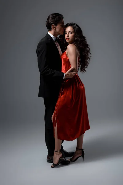 Ρομαντικό Νεαρό Ζευγάρι Κοστούμι Και Κόκκινο Μεταξωτό Φόρεμα Αγκαλιάζει Γκρι — Φωτογραφία Αρχείου