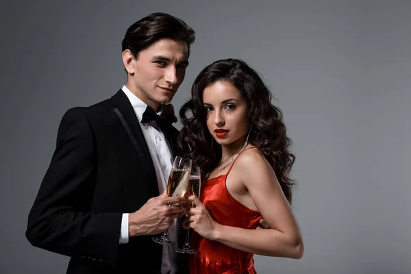 Romantický Pár Objímající Cinkající Sklenicemi Šampaňského Izolované Šedi — Stock fotografie