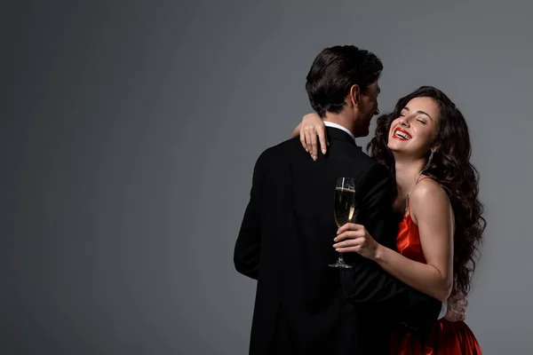 Skrattande Kvinna Kramas Man Samtidigt Hålla Glas Champagne Isolerad Grå — Stockfoto