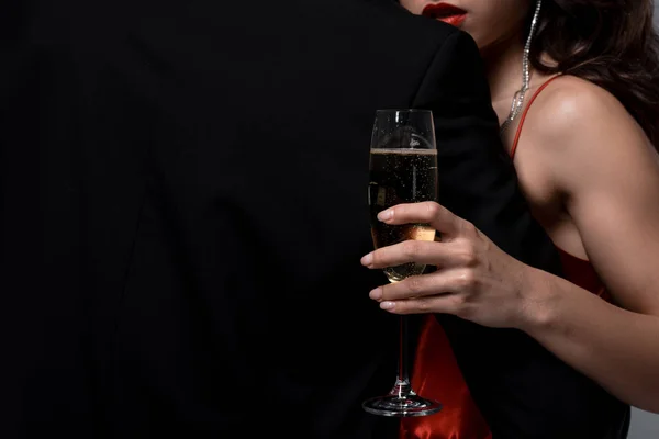 那对年轻夫妇抱着酒杯 手里拿着香槟酒 与灰色隔离的剪影 — 图库照片