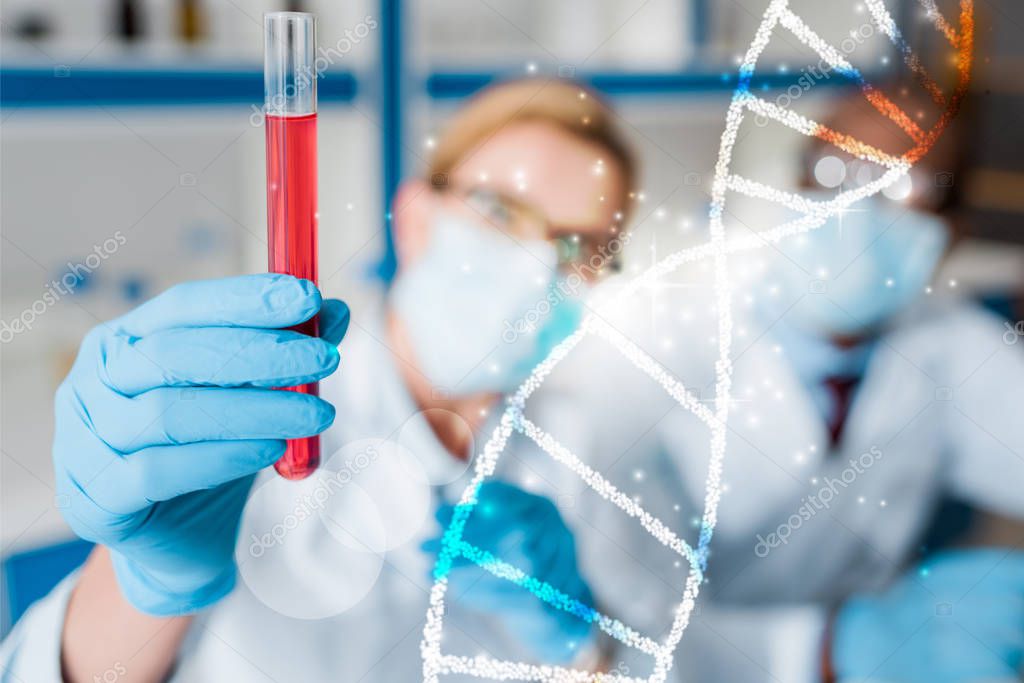 selective focus of multicultural biologists looking at test tube with dna illustration