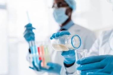 Laboratuvarda test yapan çok kültürlü biyologların seçici odağı 