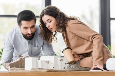 Sanal gerçeklik mimarları konuşuyor ve ev modeline bakıyor. 