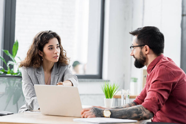 account managers talking and sitting at table in office 