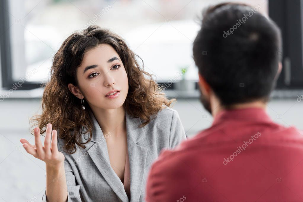 selective focus of account manager talking with colleague in office 