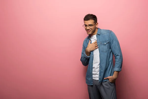 Sorrindo Homem Segurando Mão Peito Olhando Para Câmera Fundo Rosa — Fotografia de Stock