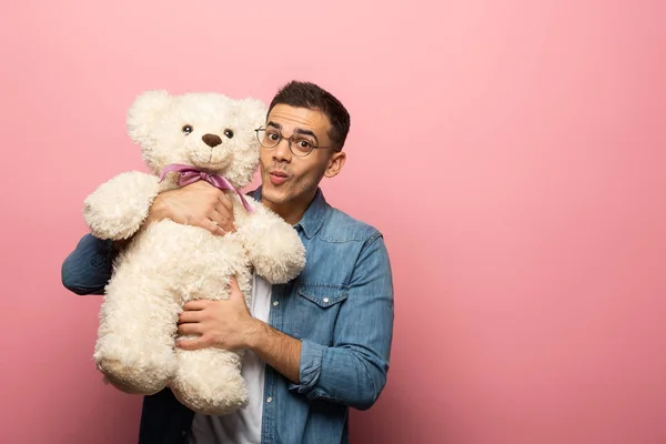 Junger Mann Grinst Die Kamera Während Einen Teddybär Auf Rosa — Stockfoto