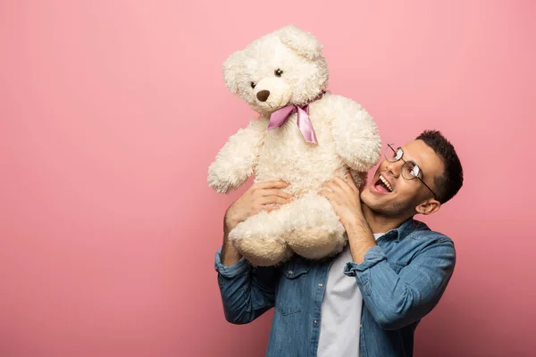 Excited Young Man Looking Teddy Bear Pink Background — Stock Photo, Image