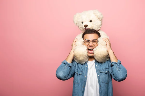 Lachender Junger Mann Blickt Die Kamera Während Einen Teddybär Auf — Stockfoto