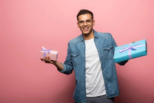 Smiling Young Man Looking Camera While Holding Gift Boxes Pink — Stock Photo, Image