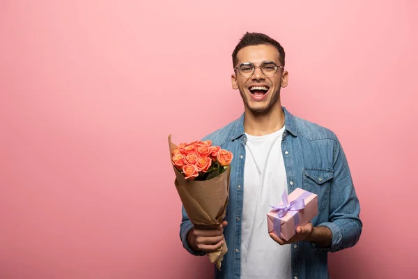 Aufgeregter Mann Mit Geschenk Und Blumen Blickt Die Kamera Auf — Stockfoto