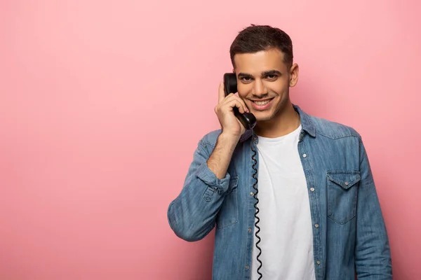 Красивий Чоловік Розмовляє Телефону Посміхається Камеру Рожевому Фоні — стокове фото
