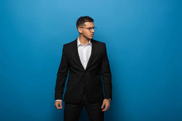 Hombre Negocios Guapo Mirando Hacia Otro Lado Sobre Fondo Azul —  Fotos de Stock