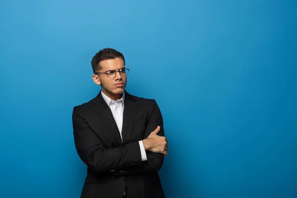 Sceptical Businessman Crossed Arms Looking Away Blue Background — Stock Photo, Image