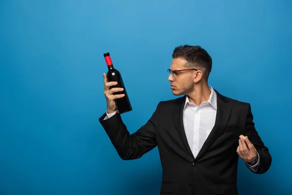 Πλευρική Άποψη Του Επιχειρηματία Κρατώντας Μπουκάλι Κρασί Και Φελλό Μπλε — Φωτογραφία Αρχείου