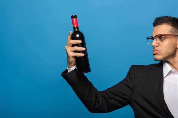 Vista Lateral Empresário Segurando Garrafa Vinho Isolado Azul — Fotografia de Stock