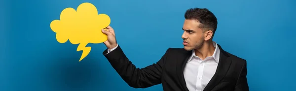 Panoramic Shot Irritated Businessman Looking Speech Bubble Blue Background — Stock Photo, Image