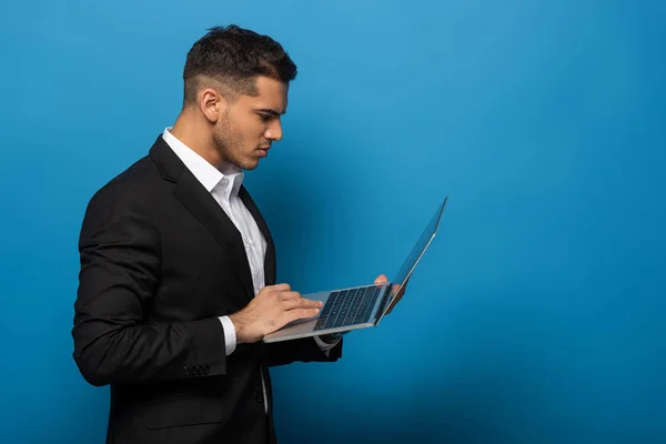 Vista Lateral Empresário Usando Laptop Fundo Azul — Fotografia de Stock
