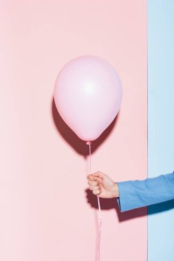 Mavi ve pembe arka planda balon tutan adamın kırpılmış görüntüsü 