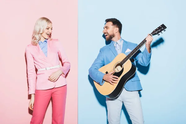 Mulher Sorridente Homem Bonito Tocando Guitarra Acústica Fundo Rosa Azul — Fotografia de Stock