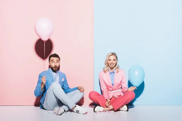 Attractive Woman Sticking Out Tongue Shocked Man Balloons Pink Blue — Stock Photo, Image