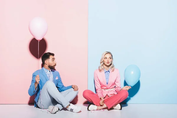 Mulher Atraente Homem Chocado Segurando Balões Fundo Rosa Azul — Fotografia de Stock