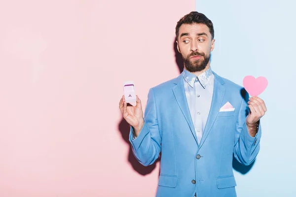 Bange Man Met Hartvormige Kaart Verlovingsring Blauwe Roze Achtergrond — Stockfoto