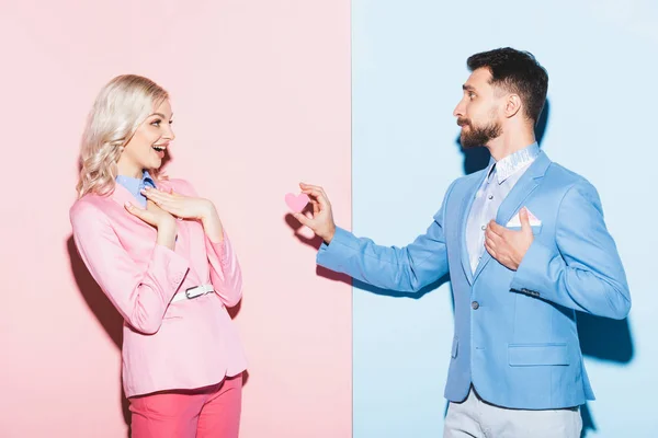 Hombre Guapo Dando Tarjeta Forma Corazón Mujer Conmocionada Sobre Fondo — Foto de Stock