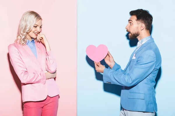 Geschokte Man Geven Hartvormige Kaart Aan Lachende Vrouw Roze Blauwe — Stockfoto