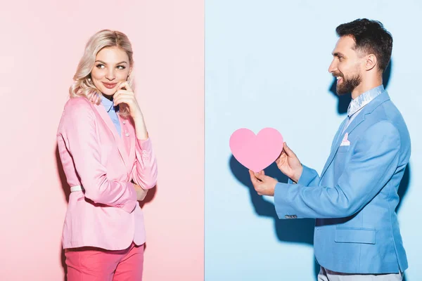 Handsome Man Giving Heart Shaped Card Dreamy Woman Pink Blue — Stock Photo, Image