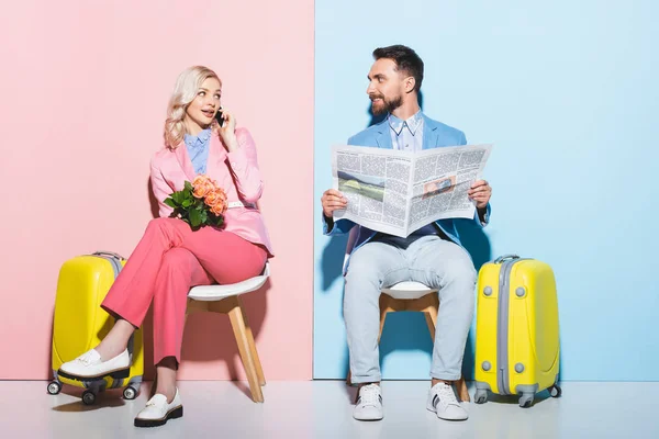 Attraente Donna Parlando Smartphone Sorridente Uomo Tenendo Giornale Sfondo Rosa — Foto Stock