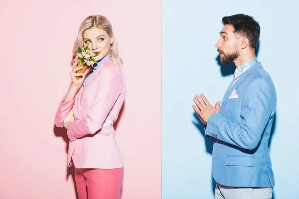 Mujer Atractiva Sosteniendo Ramo Hombre Guapo Mirándola Sobre Fondo Rosa — Foto de Stock