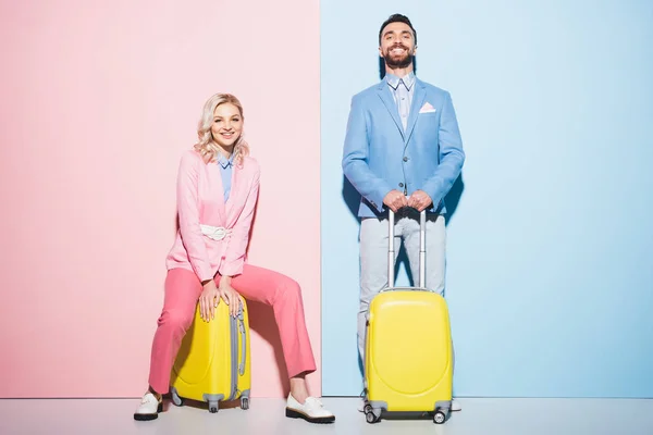 Smiling Woman Handsome Man Sitting Travel Bags Pink Blue Background — Stock Photo, Image