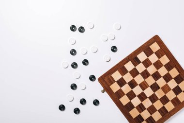 Top view of checkers and chessboard on white background clipart
