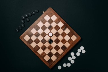 Tahta satranç tahtasındaki dama tahtası siyah üzerine izole edilmiş.