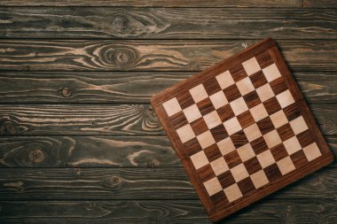Top view of chessboard on wooden surface clipart