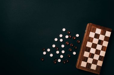 Siyah üzerine izole satranç tahtası ile beyaz ve kahverengi dama
