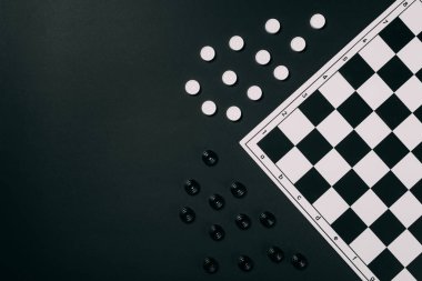Top view of black and white checkers and checkerboard isolated on black clipart