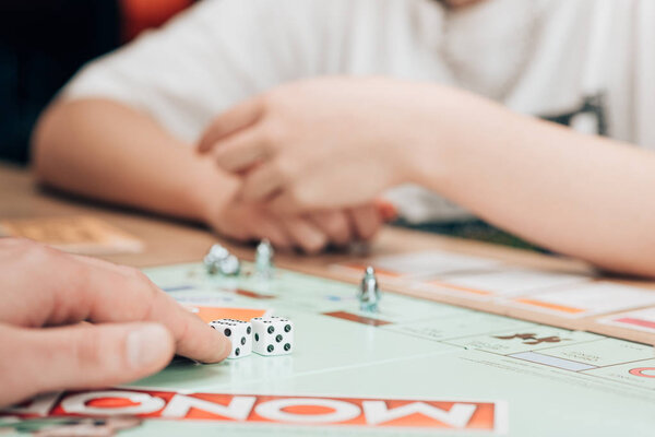 KYIV, UKRAINE - NOVEMBER 15, 2019: Selective focus of man and woman playing monopoly game at table