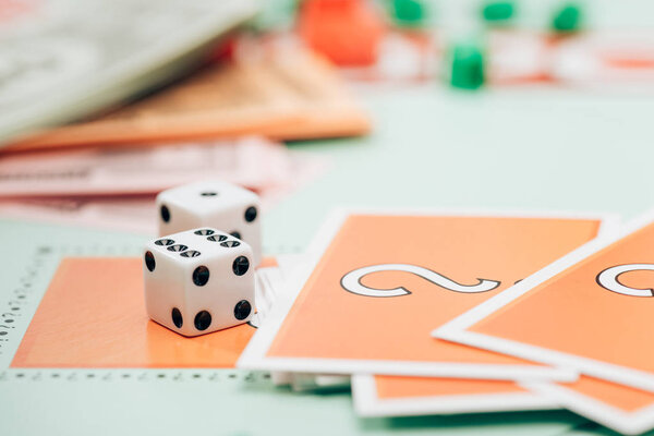 KYIV, UKRAINE - NOVEMBER 15, 2019: Selective focus of dices and cards on monopoly game