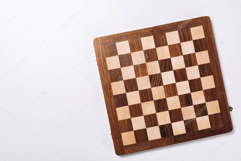 Top view of checkerboard on white background with copy space