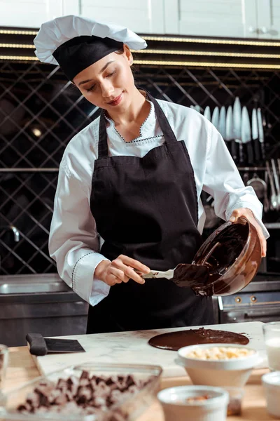 Glücklicher Chocolatier Gießt Geschmolzene Schokolade Auf Marmoroberfläche — Stockfoto