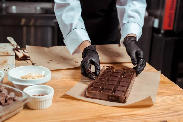 Vista Cortada Chocolatier Segurando Moldes Chocolate Com Chocolate Perto Papel — Fotografia de Stock