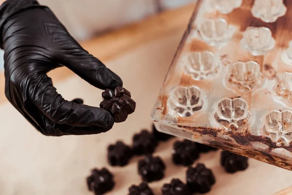 Close Chocolatier Segurando Chocolate Doce Perto Moldes Chocolate — Fotografia de Stock