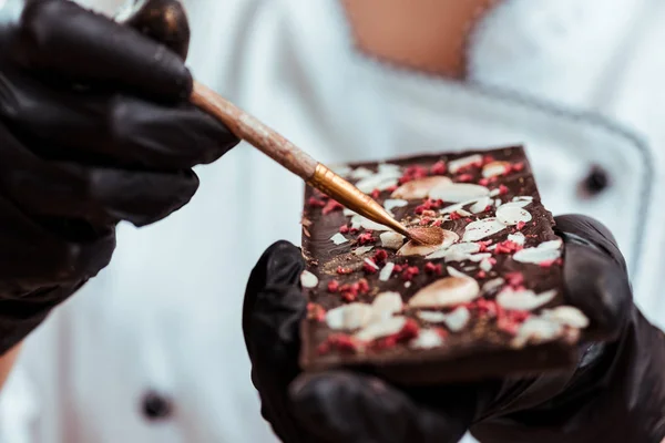 Închiderea Ciocolatei Care Ține Peria Lângă Barul Ciocolată Gustos — Fotografie, imagine de stoc