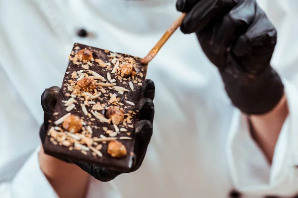 Close Chocolatier Holding Brush Tasty Chocolate Bar Hazelnuts — Stock Photo, Image